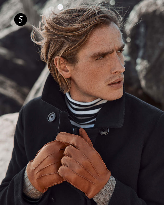 man wearing leather gloves with cashmere cuffs in cognac at the beach