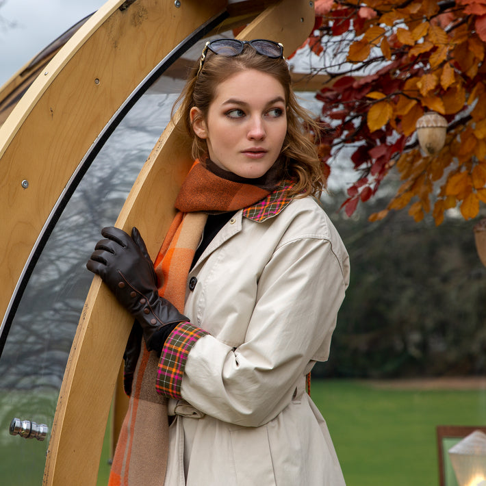 Woman wearing brown leather gloves and an orange scarf
