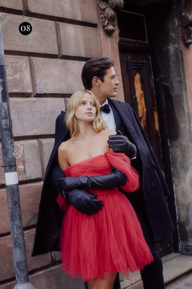 Couple wearing black leather gloves with evening attire in the city