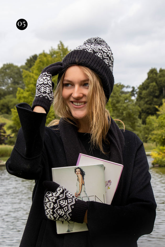Woman wearing fair isle knitted gloves and hat in black in the park