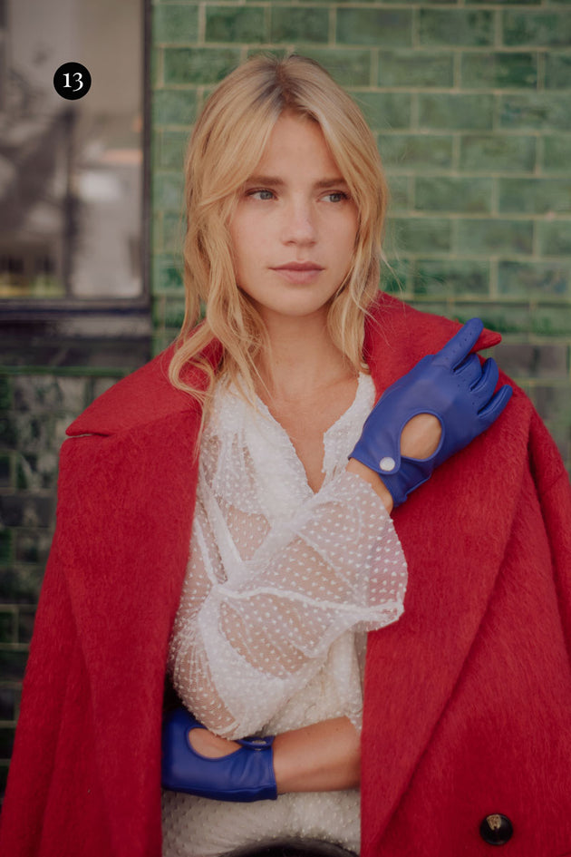 Woman wearing driving gloves in marine with a red coat in the city