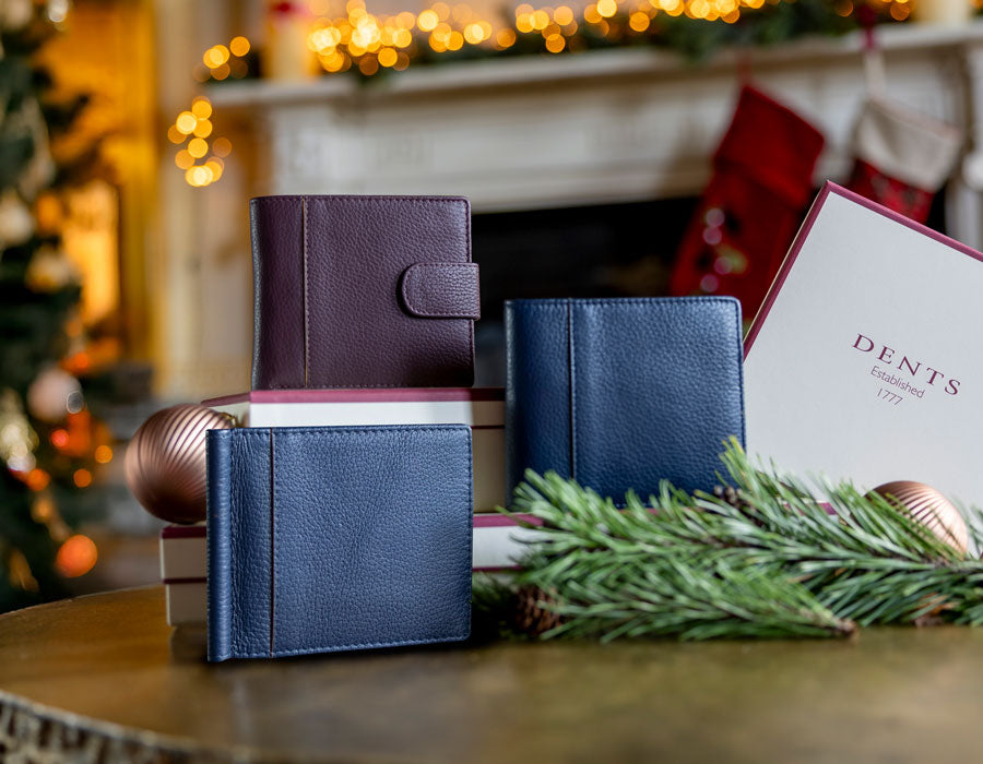 MEN'S LEATHER WALLETS IN VARIOUS COLOURS ON SOFA WITH A CHRISTMASSY BACKGROUND