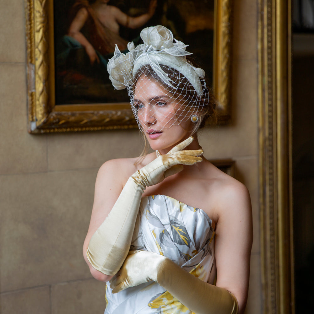 Woman wearing long gold satin gloves and a cocktail dress at a party