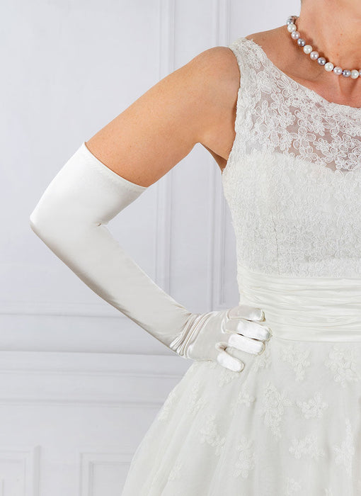 Woman wearing ivory opera satin gloves with a wedding dress