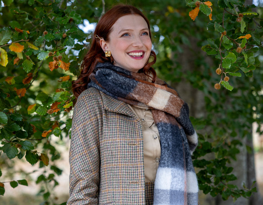 Woman wearing blanket scarf in brown outdoors