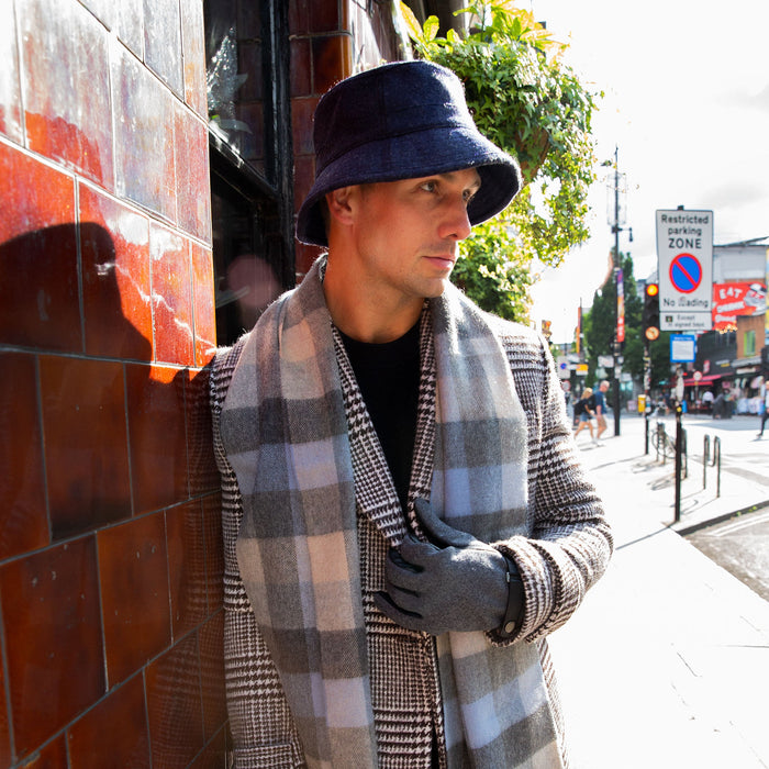 Man wearing cashmere scarf in sky with gloves and bucket hat outside a cafe