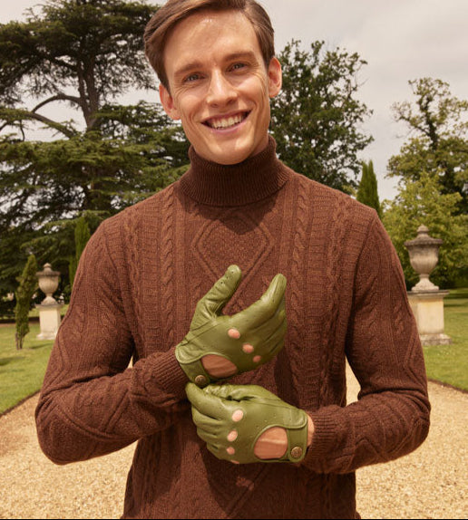 Man wearing green leather driving gloves in the park