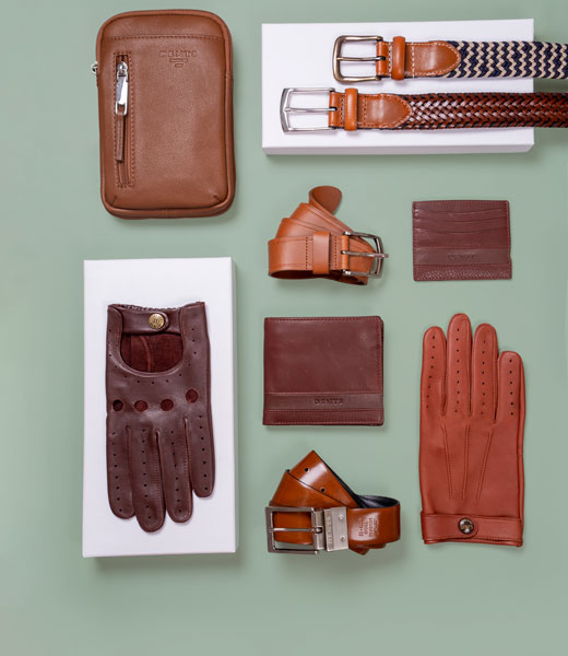 Men's leather accessories in brown colours on a green background