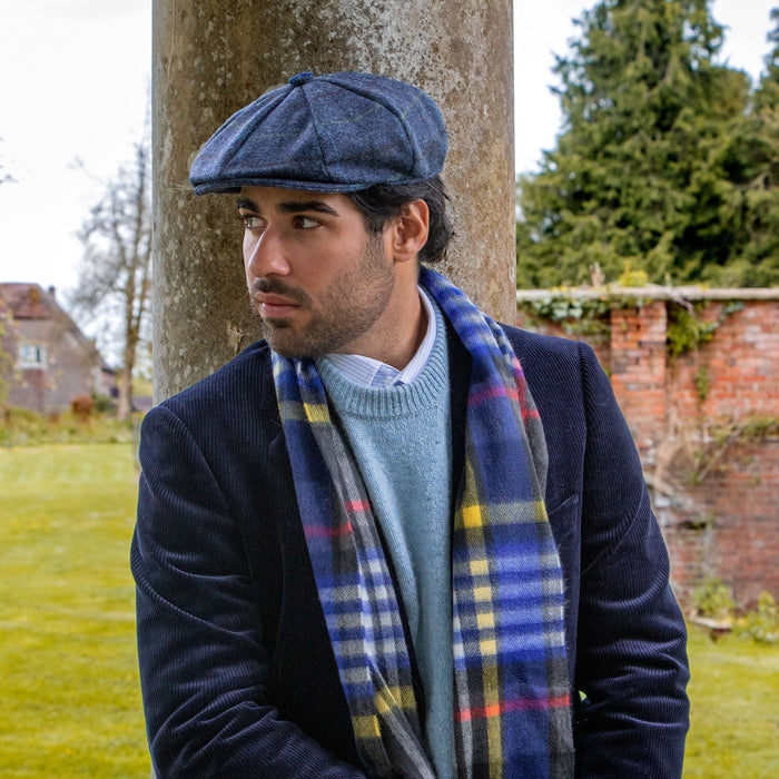 Man wearing heritage cashmere scarf in night sky with a tweed flat cap