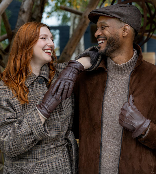 Man and woman wearing heritage leather gloves in brown shades outdoors