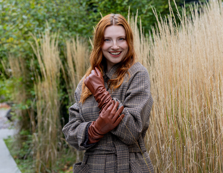 Woman wearing long leather gloves in cognac outdoors