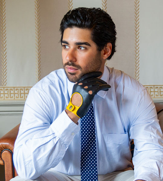 Man wearing black leather driving gloves with yellow detailing