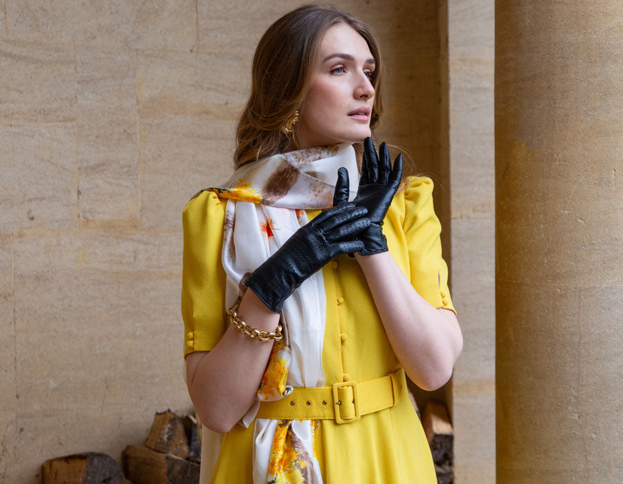 Woman wearing black perforated gloves with yellow dress outdoors