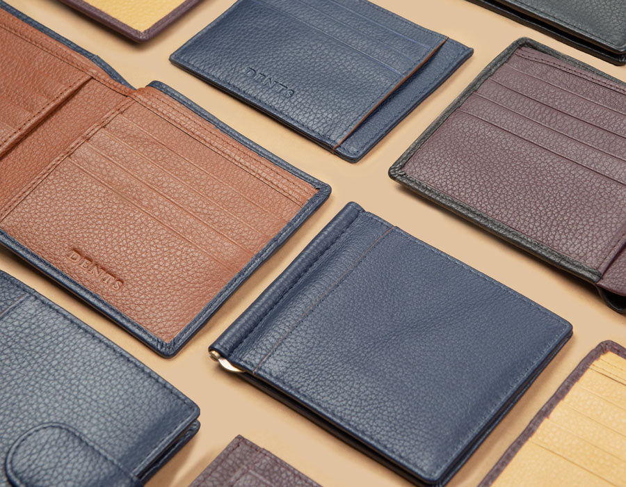 Various men's wallets, card holders, money clips in different colours on a table.