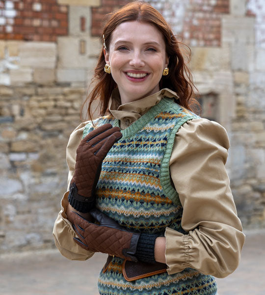 Woman wearing brown water-resistant leather gloves with knit cuff in windy weather.