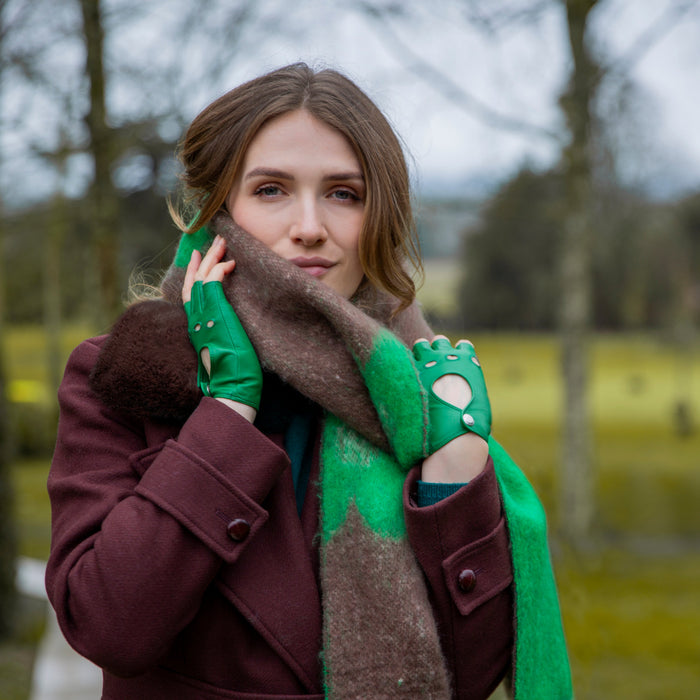 Woman wearing Fingerless Leather Driving Gloves in Emerald in a park