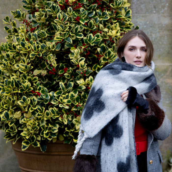 Woman wearing Black Reversible Floral Blanket Scarf with Tassels in a park