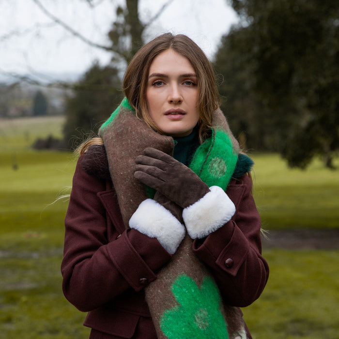 Woman wearing Emerald Reversible Floral Blanket Scarf with Tassels in a park