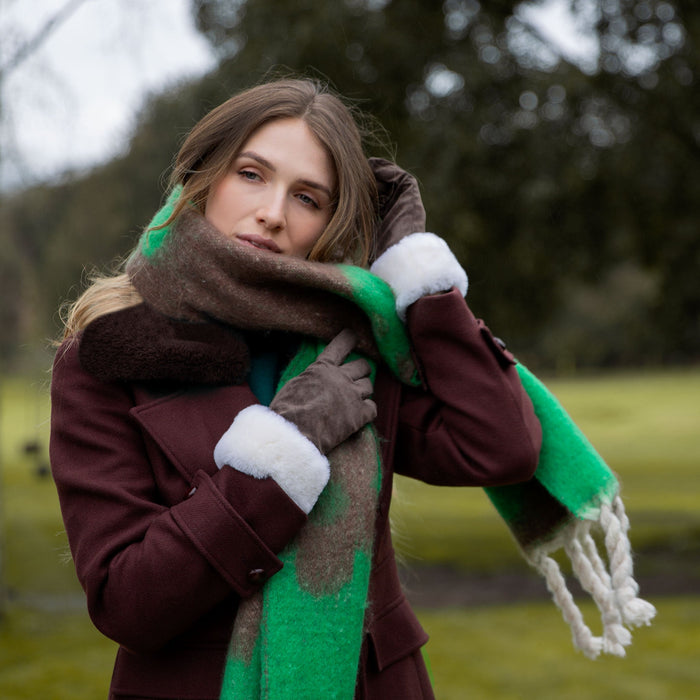 Woman wearing Emerald Reversible Floral Blanket Scarf with Tassels in a park