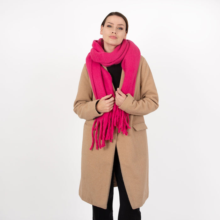 Woman wearing blanket scarf with tassels in fuchsia 