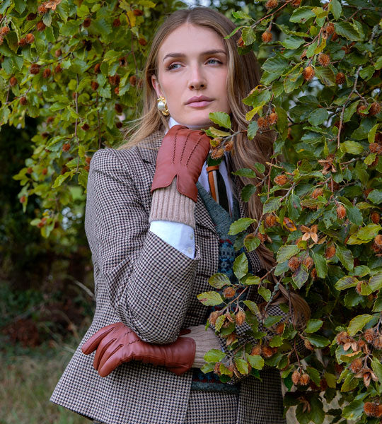 Woman wearing leather gloves with knitted cuffs in cognac 