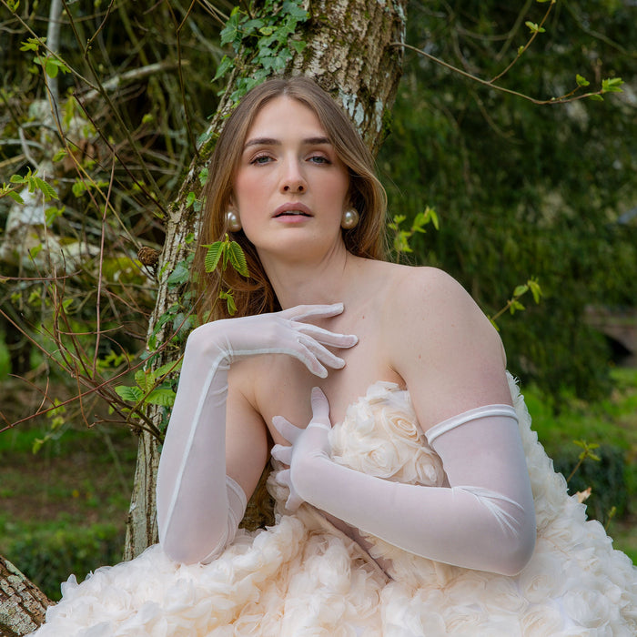 Woman wearing long tulle gloves in ivory