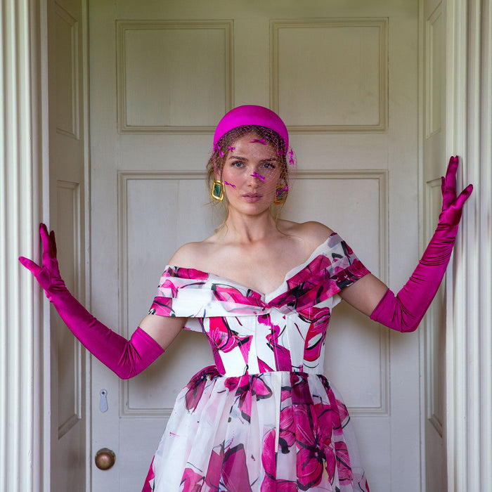 Woman wearing long opera satin gloves in fuchsia at a party