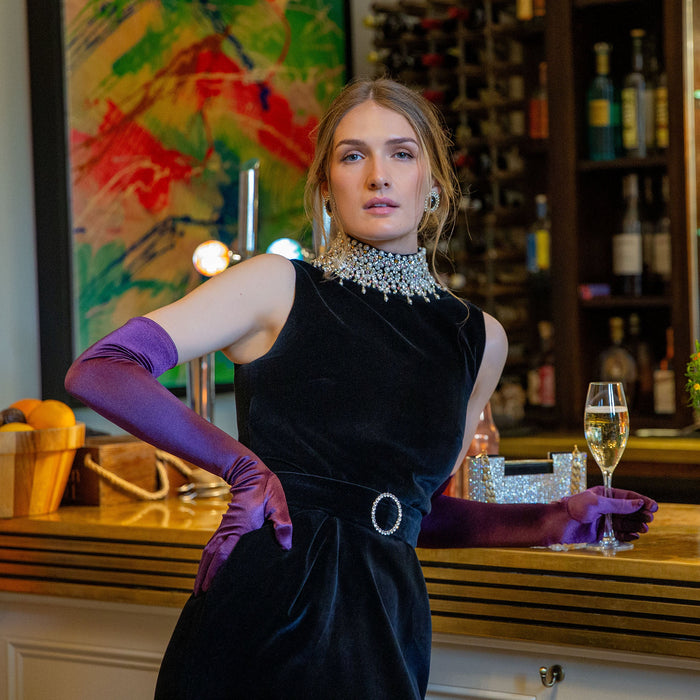 Woman wearing long opera satin gloves in amethyst at an event