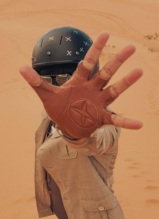 Man wearing fingerless crochet back leather driving gloves for men