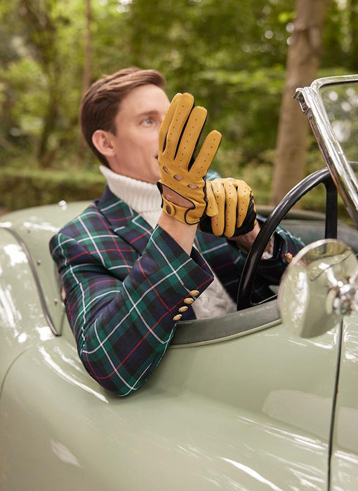man putting gloves on in vintage car