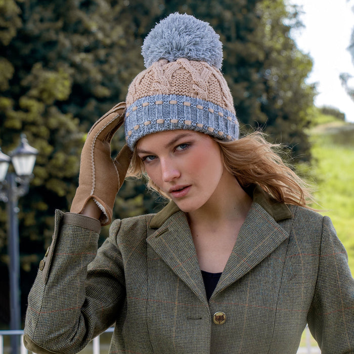Woman wearing camel and dove grey knitted hat in a park